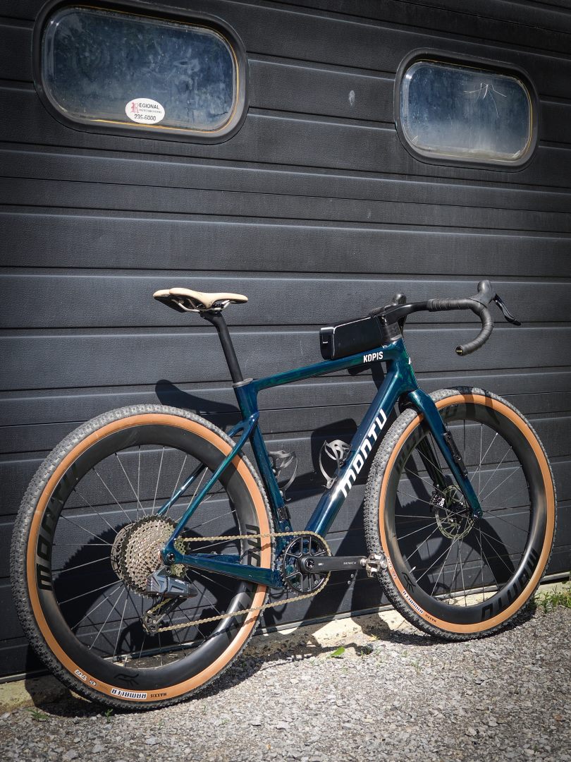 Montu Kopis emerald three-quarter rear showing Wheeltop drivetrain and gravel tires