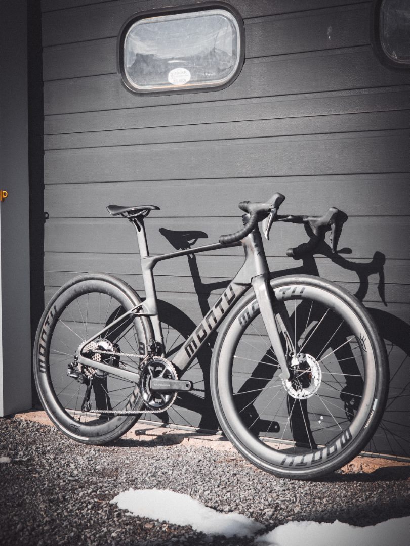 Montu Nui V2 in naked carbon with gloss black accents, three-quarter front view